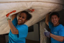 Two volunteers carry a mattress